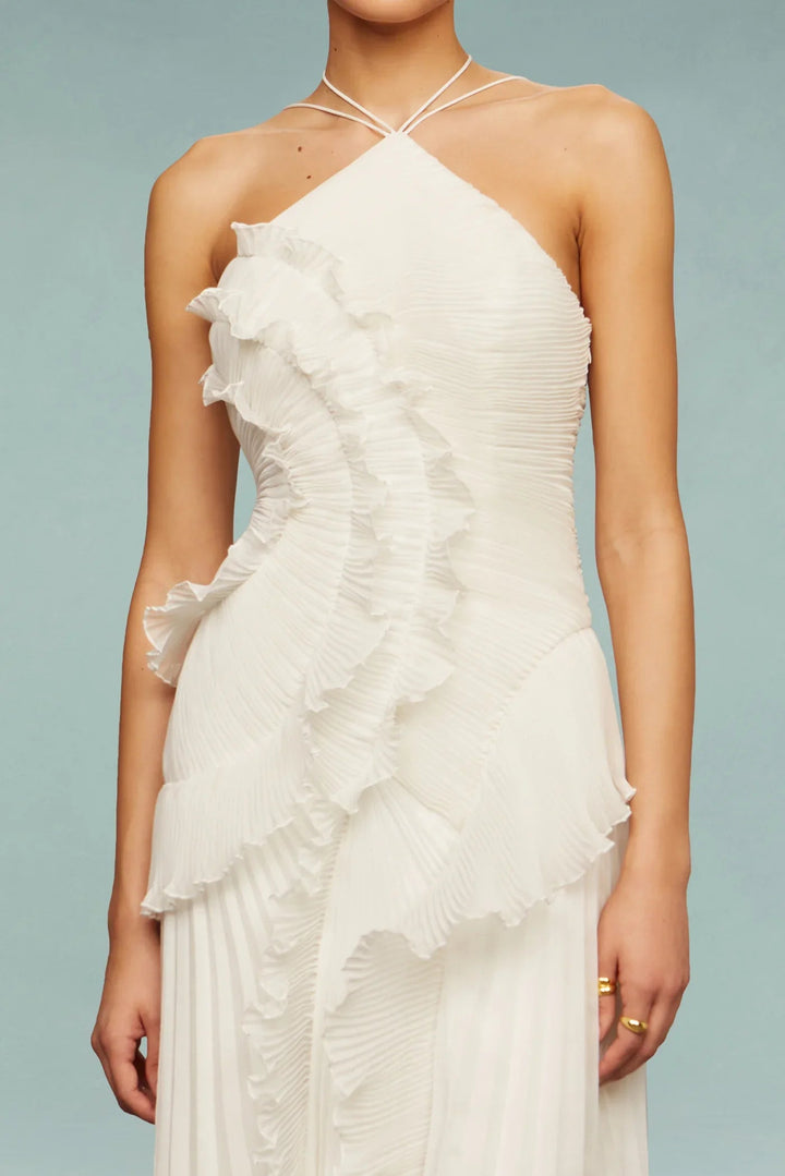 Female model wearing asymmetrical neckline dress with relaxed elegant posture.