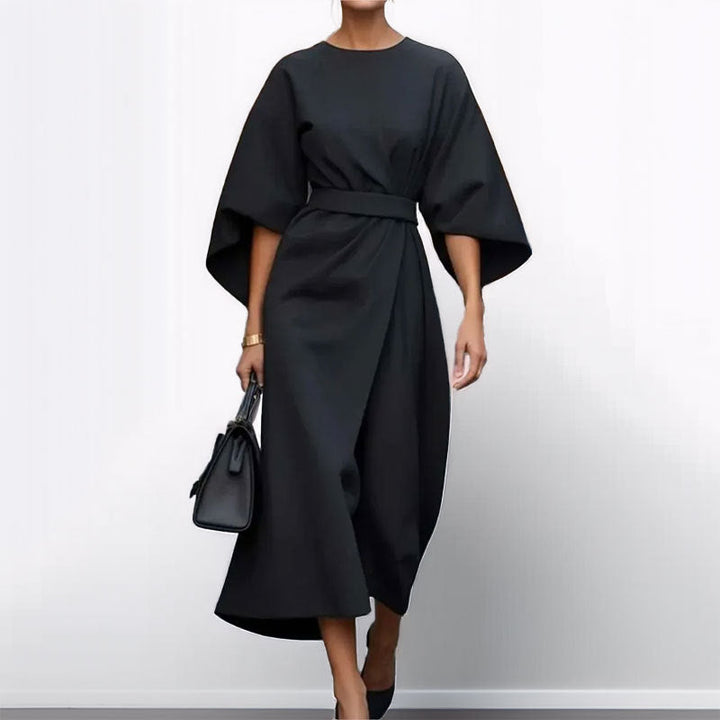 Woman showcasing a flowing batwing sleeve maxi dress on a clean background.