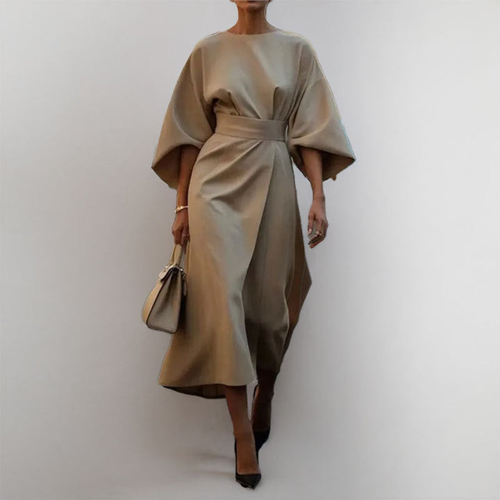 Model in a formal satin batwing maxi dress with a flattering waist on a clean background.