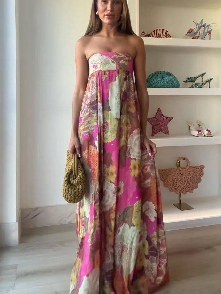 Woman in strapless printed maxi dress with plain zoom background setting.
