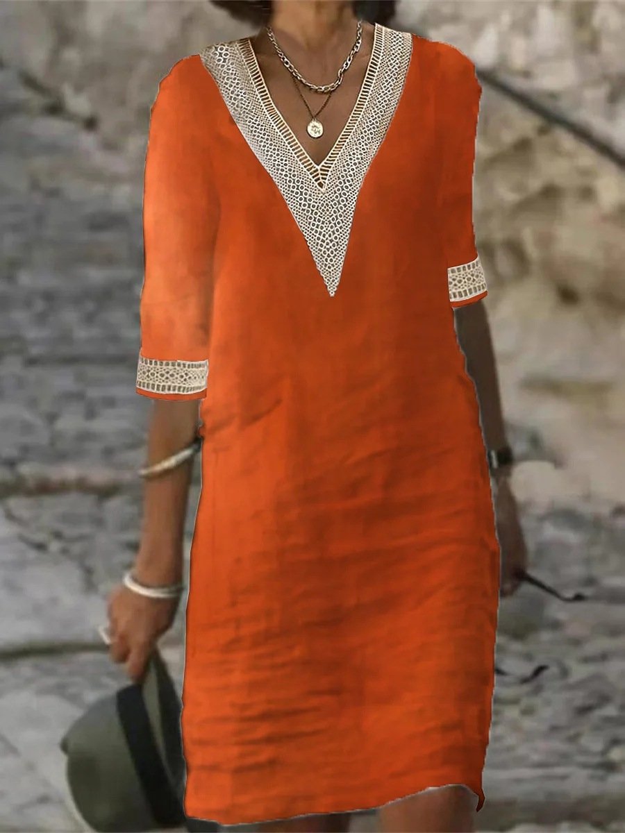 Woman wearing a V-neck lace trim midi dress with 3/4 sleeves against a nature stone wall background.