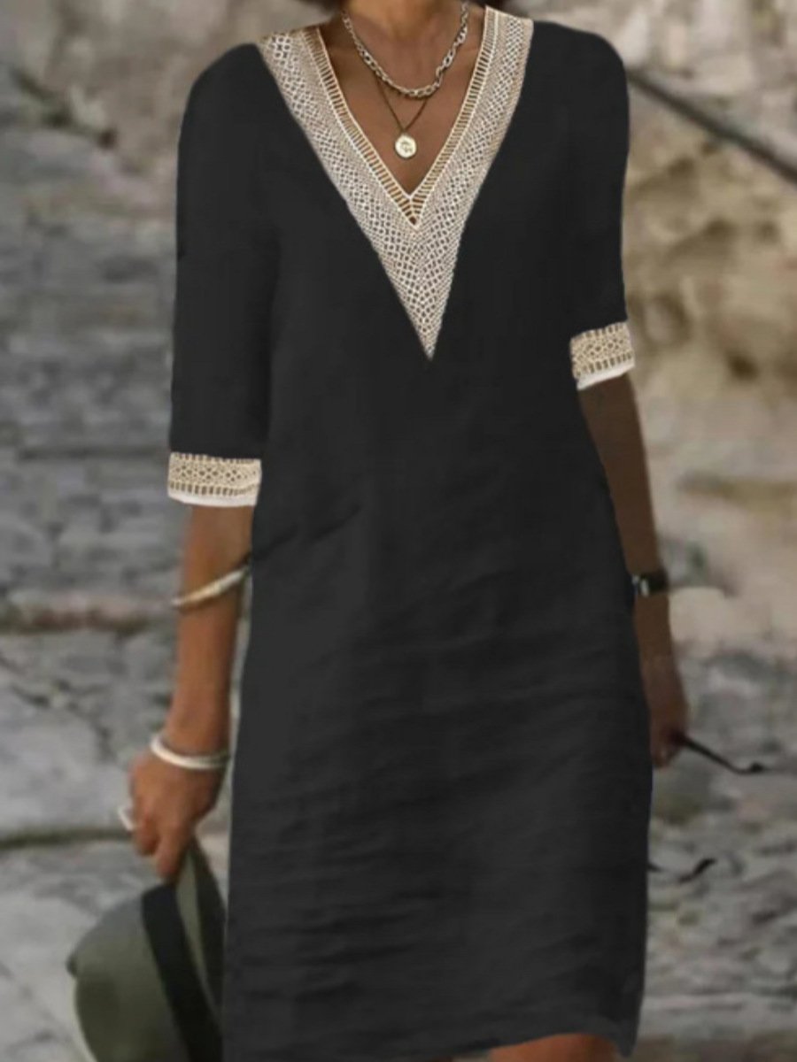 Woman styling a lace trim midi dress with a soft outdoor stone wall background.