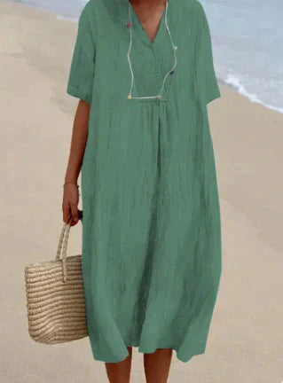 Woman styled in a breathable relaxed midi dress with a plain background.