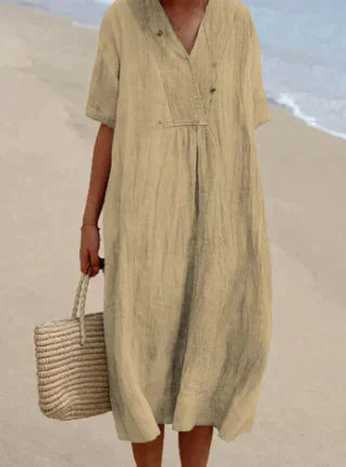 Female in a relaxed fit midi dress with a simple plain background.