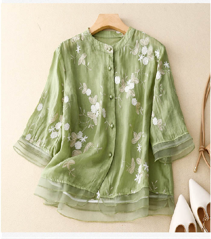 Elegant embroidered women’s blouse displayed on a clean plain background.