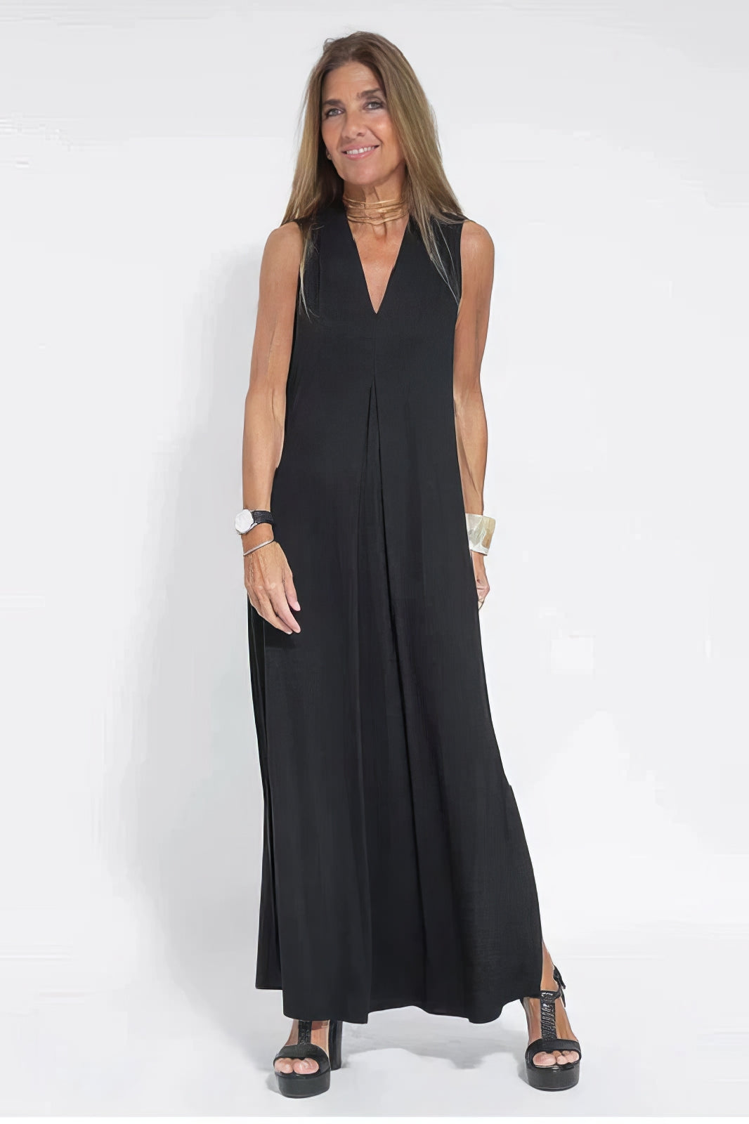 Elegant long dress w/ model on a plain background, showing a soft flowing silhouette.