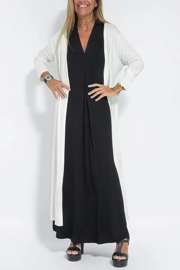 Graceful long dress w/ model on a plain background, designed with a smooth draped look.