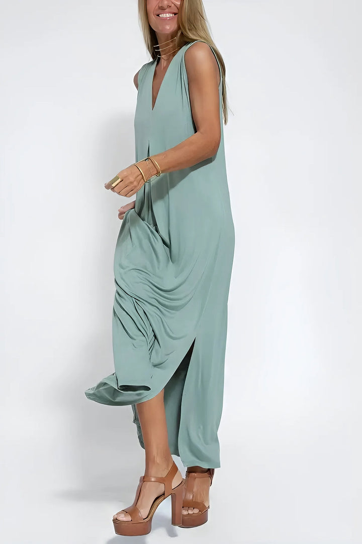 Sophisticated long dress w/ model on a plain background, featuring a flattering relaxed fit.